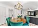 Bright breakfast nook features stylish lighting and a round table with four emerald-green chairs at 8078 Longleaf Dr, Villa Rica, GA 30180