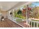 Inviting covered porch with wood flooring, white railing and hanging plants at 8078 Longleaf Dr, Villa Rica, GA 30180