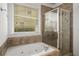 A bathroom with a tub, shower, and a window allowing natural light to illuminate the space at 1514 Gilstrap Nw Ln, Atlanta, GA 30318