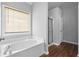 Bathroom featuring tub with tile surround, shower, and window with blinds at 1710 Brandon Lee Sw Way, Marietta, GA 30008
