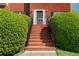 Close-up of the red brick steps and front door of a charming home, surrounded by lush greenery at 1710 Brandon Lee Sw Way, Marietta, GA 30008