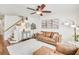 Inviting living room featuring a comfortable leather sofa, stylish decor, and a ceiling fan for added comfort at 44 Hall Mnr, Alpharetta, GA 30022