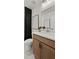 Well-lit bathroom with a white marble vanity, a wooden cabinet, and a black shower curtain at 5310 Julep Ct, Cumming, GA 30028