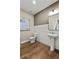 Modern half bath with wood floors, pedestal sink, and neutral walls offers a clean and functional space at 5310 Julep Ct, Cumming, GA 30028