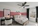 Cozy bedroom with a pink accent wall, a comfortable bed, and a large window at 5310 Julep Ct, Cumming, GA 30028