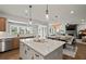 An open concept kitchen with island, pendant lights and stainless appliances overlooks dining and living room at 5310 Julep Ct, Cumming, GA 30028