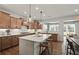 A modern kitchen with wood cabinets, stainless steel appliances, a large island and an open view of the dining room at 5310 Julep Ct, Cumming, GA 30028