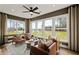 A bright sunroom boasts large windows, hardwood floors, neutral decor, and comfortable seating at 5310 Julep Ct, Cumming, GA 30028