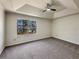 Relaxing main bedroom boasts a tray ceiling, a ceiling fan, and a large bright window at 9704 Pintail Trl, Jonesboro, GA 30238