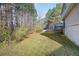 Backyard with a grassy lawn and a mix of mature trees and wooded area at 6595 Lancelot Ct, Riverdale, GA 30296