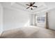 Spacious bedroom with a tray ceiling, a ceiling fan, carpet flooring, and a bright window at 6595 Lancelot Ct, Riverdale, GA 30296