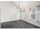 Elegant dining area featuring modern lighting, dark laminate flooring, and bright windows at 6595 Lancelot Ct, Riverdale, GA 30296