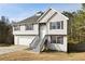 Charming two-story home with stone accents, a well-maintained lawn, and a two-car garage at 6595 Lancelot Ct, Riverdale, GA 30296