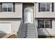 Inviting front entrance with gray stairs, a decorative stone archway, and a bright white door at 6595 Lancelot Ct, Riverdale, GA 30296