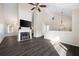 Spacious open-concept living room with vaulted ceilings, fireplace, and dark laminate flooring at 6595 Lancelot Ct, Riverdale, GA 30296