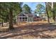 Backyard view of a brick home with a screened porch, deck, mature trees and landscaping at 2947 Margaret Mitchell Nw Ct, Atlanta, GA 30327