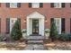 Elegant front entrance with a decorative door, lantern sconces, and manicured greenery at 2947 Margaret Mitchell Nw Ct, Atlanta, GA 30327