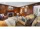 Cozy living room with a fireplace, wood paneling, and plush seating arrangements at 2947 Margaret Mitchell Nw Ct, Atlanta, GA 30327