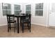 Cozy breakfast nook featuring a black table with four chairs, tile flooring and three bright windows at 55 Bonds Ct, Hiram, GA 30141