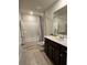 Clean bathroom featuring a shower-tub combo, granite counters, and dark wood cabinets at 1001 Brading Pl, Lawrenceville, GA 30043