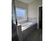 Bathroom featuring a soaking tub, shower, and tile surround at 1001 Brading Pl, Lawrenceville, GA 30043