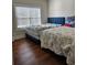 Shared bedroom with hardwood floors, two beds, and large sunny window at 1001 Brading Pl, Lawrenceville, GA 30043