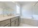 Bright bathroom with a soaking tub, quartz counters, gray cabinets, and a separate shower at 10035 River Rock Dr, Roswell, GA 30076