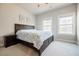 Cozy bedroom featuring a comfortable bed, a nightstand, and natural light streaming through two windows at 10035 River Rock Dr, Roswell, GA 30076