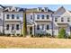 Charming three-story townhome with a manicured front yard and classic architectural details at 10035 River Rock Dr, Roswell, GA 30076