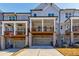 Townhome rear exterior with private decks above the garages, set on a sunny day with blue sky at 10035 River Rock Dr, Roswell, GA 30076