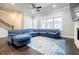 Bright living room with hardwood floors, a ceiling fan, a large window, and a comfortable sectional sofa at 10035 River Rock Dr, Roswell, GA 30076