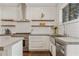 Modern kitchen with stainless steel appliances, custom floating shelves, white tile backsplash, and gas range at 1784 Terry Mill Se Rd, Atlanta, GA 30316