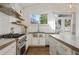 Well-lit kitchen equipped with modern appliances, gas range, custom shelving, and a view of the backyard at 1784 Terry Mill Se Rd, Atlanta, GA 30316