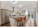 Open kitchen with stainless steel appliances, gas range, tile backsplash, island seating, and double doors to yard at 1784 Terry Mill Se Rd, Atlanta, GA 30316