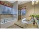 Bright bathroom with a granite countertop, soaking tub, and a glass enclosed shower at 480 Firelite Ln, Suwanee, GA 30024
