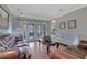 Elegant living room featuring hardwood floors, a tufted leather sofa, and French doors at 480 Firelite Ln, Suwanee, GA 30024