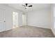 Spacious bedroom featuring a ceiling fan, neutral carpet, and an ensuite bathroom at 5960 Magnolia Rdg, Stone Mountain, GA 30087
