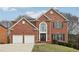 Attractive brick home featuring a two-car garage, manicured lawn, and mature landscaping at 5960 Magnolia Rdg, Stone Mountain, GA 30087