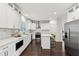 Bright kitchen features white cabinets, stainless steel appliances, marble backsplash, hardwood floors, and a kitchen island at 5960 Magnolia Rdg, Stone Mountain, GA 30087
