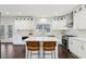 Bright kitchen features white cabinets, stainless steel appliances, marble backsplash, hardwood floors, and a kitchen island at 5960 Magnolia Rdg, Stone Mountain, GA 30087