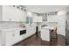 Bright kitchen features white cabinets, stainless steel appliances, marble backsplash, hardwood floors, and a kitchen island at 5960 Magnolia Rdg, Stone Mountain, GA 30087