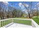 Expansive backyard features a white railing deck, lush green grass, mature trees, and string lights overhead at 5450 Frazer Rd, Buford, GA 30518