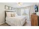 Bright bedroom boasts a plush bed, neutral walls, ceiling fan, and a window with natural light exposure at 5450 Frazer Rd, Buford, GA 30518