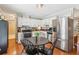 Eat-in kitchen featuring stainless steel appliances, white cabinetry, and hardwood floors at 5450 Frazer Rd, Buford, GA 30518