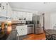 Well-lit kitchen featuring stainless steel appliances, white cabinetry, and hardwood floors at 5450 Frazer Rd, Buford, GA 30518
