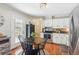 Eat-in kitchen featuring stainless steel appliances, white cabinetry, and hardwood floors at 5450 Frazer Rd, Buford, GA 30518