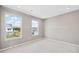 Bright bedroom featuring dual windows offering neighborhood views and neutral paint at 61 Okeechobee Way, Braselton, GA 30548