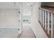 Bright hallway featuring staircase with wooden handrail and large windows at the far end at 61 Okeechobee Way, Braselton, GA 30548