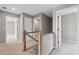 Hallway with wooden railings leading to multiple rooms, showcasing open floor design at 61 Okeechobee Way, Braselton, GA 30548
