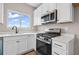 Kitchen showcasing white cabinetry, stainless steel appliances and quartz countertops at 61 Okeechobee Way, Braselton, GA 30548